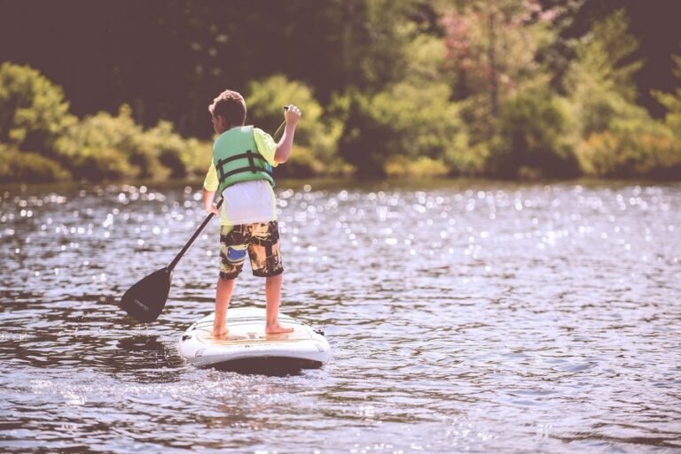 Enfant faisant du paddleboard avec un gilet de sauvetage